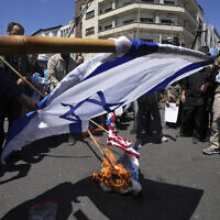 Des manifestants iraniens brûlant des représentations des drapeaux israélien et américain lors de leur rassemblement à l'occasion de la "Journée de Jérusalem", une manifestation annuelle de soutien aux Palestiniens, à Téhéran, en Iran, le 14 avril 2023. (Crédit : AP Photo/Vahid Salemi)