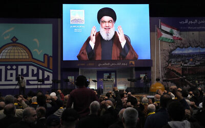 Le chef du Hezbollah, Sayyed Hassan Nasrallah, saluant ses partisans par liaison vidéo depuis un lieu tenu secret, lors d'un rassemblement pour marquer la Journée d'Al-Qods, dans la banlieue sud de Beyrouth, au Liban, le 14 avril 2023. (Crédit : Hussein Malla/AP Photo) Le chef du Hezbollah, Sayyed Hassan Nasrallah, saluant ses partisans par liaison vidéo depuis un lieu tenu secret, lors d'un rassemblement pour marquer la Journée d'Al-Qods, dans la banlieue sud de Beyrouth, au Liban, le 14 avril 2023. (Crédit : Hussein Malla/AP Photo)