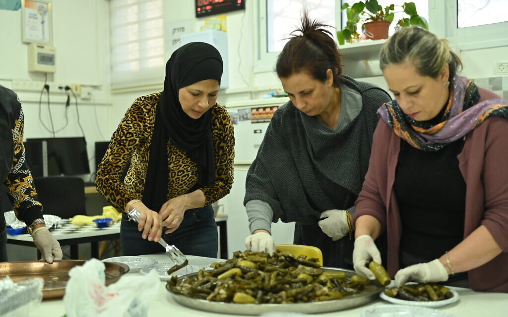 Des femmes préparant des plats pour l'iftar à l'école primaire Ahva à Haïfa, le 13 avril 2023. (Crédit : Canaan Lidor/Times of Israel)