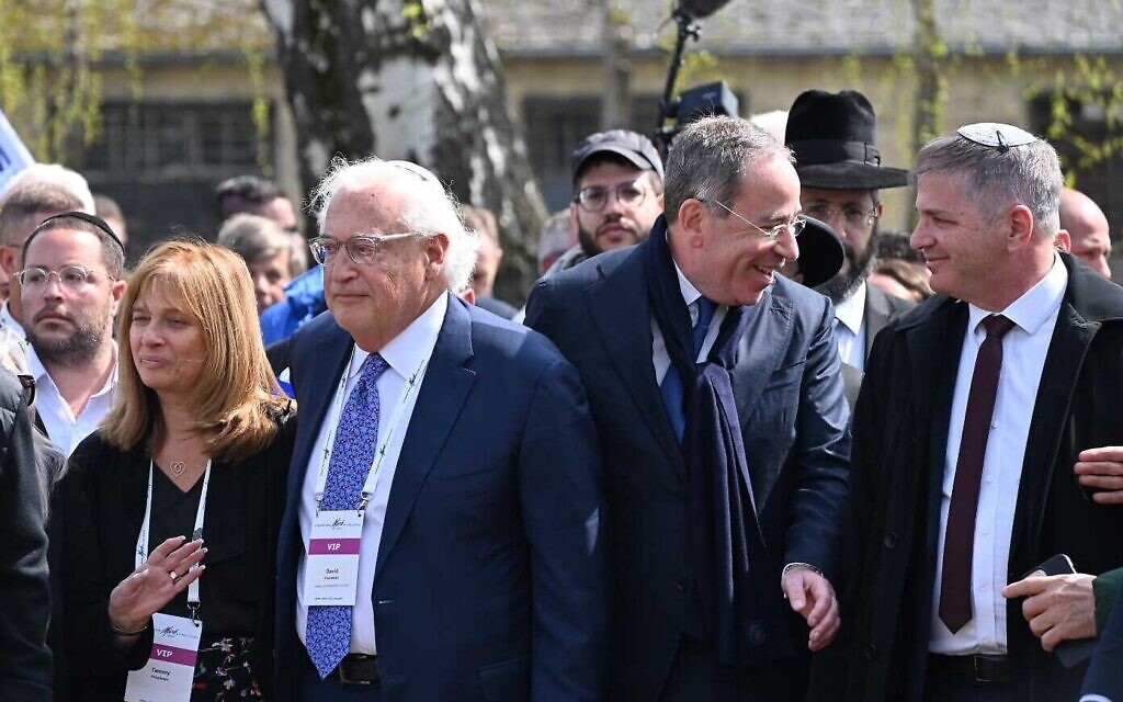 L'actuel ambassadeur des États-Unis en Israël, Tom Nides, deuxième à partir de la droite, et l'ancien ambassadeur des États-Unis, David Friedman, troisième à partir de la droite, ont allumé ensemble une torche lors de la Marche des Vivants, à Auschwitz, le 18 avril 2023. (Crédit : Canaan Lidor/Times of Israel)