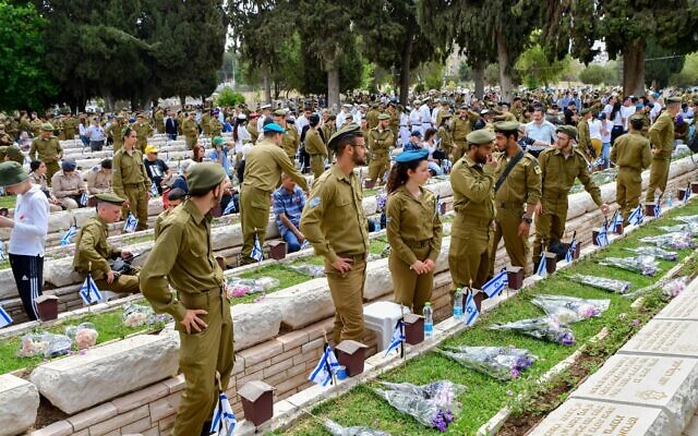 Des civils et des soldats se rendent sur les tombes à l'occasion de la journée commémorative des soldats israéliens tombés au combat et des victimes du terrorisme, au cimetière militaire Nahalat Yitzhak, à Tel Aviv, le 4 mai 2022. (Crédit : Avshalom Sassoni/Flash90) Des civils et des soldats se rendent sur les tombes à l'occasion de la journée commémorative des soldats israéliens tombés au combat et des victimes du terrorisme, au cimetière militaire Nahalat Yitzhak, à Tel Aviv, le 4 mai 2022. (Crédit : Avshalom Sassoni/Flash90)