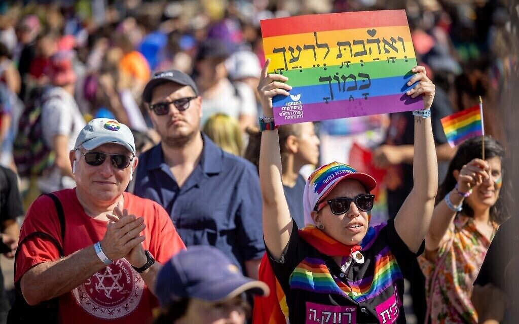 Une femme au défilé annuel de la Gay Pride à Jérusalem, le 2 juin 2022, brandit une pancarte revêtue de la phrase biblique 'Aime ton prochain comme toi-même.' (Crédit : Yonatan Sindel/Flash90) Une femme au défilé annuel de la Gay Pride à Jérusalem, le 2 juin 2022, brandit une pancarte revêtue de la phrase biblique 'Aime ton prochain comme toi-même.' (Crédit : Yonatan Sindel/Flash90)