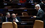 Le Premier ministre Benjamin Netanyahu, à droite, s'entretenant avec le chef du Shas, Aryeh Deri, au centre, et le ministre de la Justice, Yariv Levin, lors de la séance plénière de la Knesset, à Jérusalem, le 27 mars 2023. (Crédit : Yonatan Sindel/Flash90)