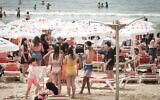 Des Israéliens se pressant sur la plage de Tel Aviv par une chaude journée, pendant les vacances de Pesssah, le 9 avril 2023. (Crédit : Avshalom Sassoni/FLASH90)