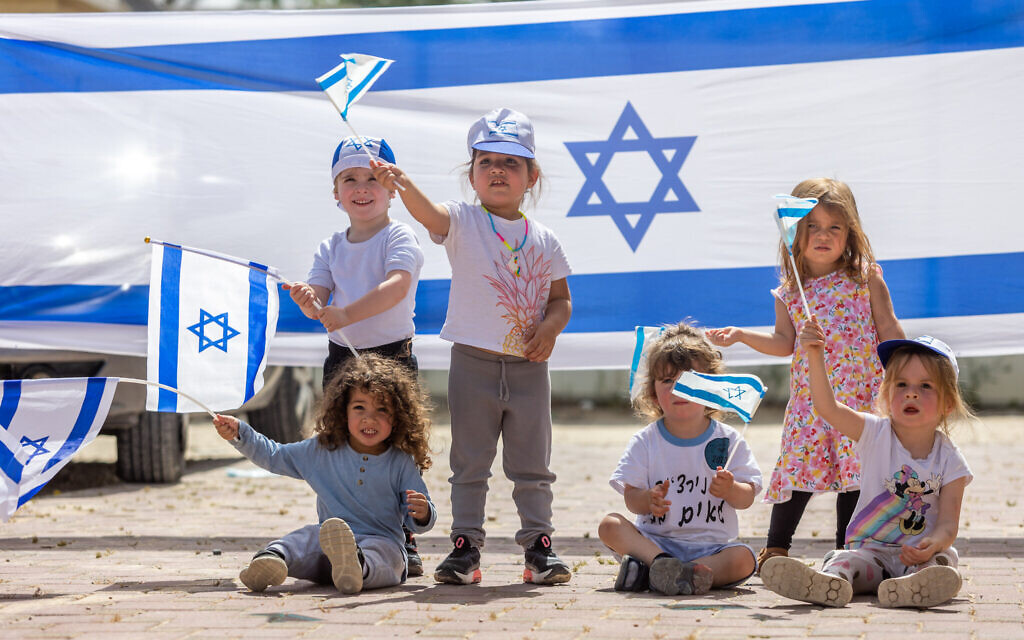 Des enfants jouant avec des drapeaux israéliens à l'approche du 75e anniversaire de l'Indépendance d'Israël, au moshav Yashresh, le 19 avril 2023. (Crédit : Yossi Aloni/Flash90) Des enfants jouant avec des drapeaux israéliens à l'approche du 75e anniversaire de l'Indépendance d'Israël, au moshav Yashresh, le 19 avril 2023. (Crédit : Yossi Aloni/Flash90)