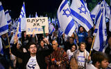 Des manifestants anti-réforme judiciaire sont rassemblés à quelques mètres de la cérémonie officielle qui célébre le 75e Jour de l’indépendance d’Israël, sur le Mont Herzl, à Jérusalem, le 25 avril 2023. (Crédit : Arie Leib Abrams/Flash90)