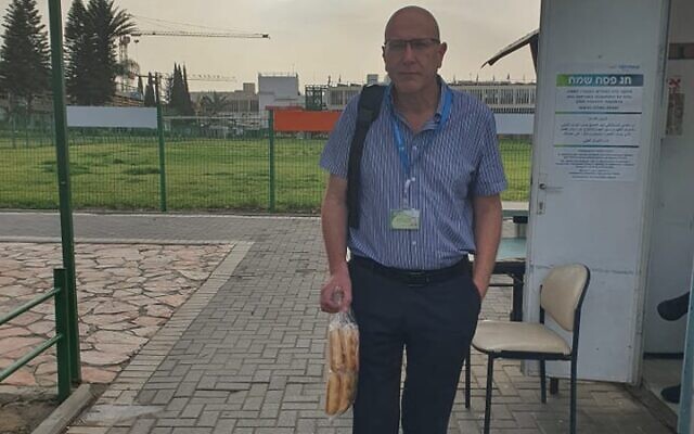 Gal Ifergane, directeur du service de neurologie, pose aux abords de l'hôpital Soroka de Beer Sheva avec les pains qu'il a amenés en défiance contre la loi sur le hametz, qui interdit l'entrée de produits alimentaires levés dans les établissements hospitaliers. (Crédit : Gal Ifergane, via Facebook) Gal Ifergane, directeur du service de neurologie, pose aux abords de l'hôpital Soroka de Beer Sheva avec les pains qu'il a amenés en défiance contre la loi sur le hametz, qui interdit l'entrée de produits alimentaires levés dans les établissements hospitaliers. (Crédit : Gal Ifergane, via Facebook)