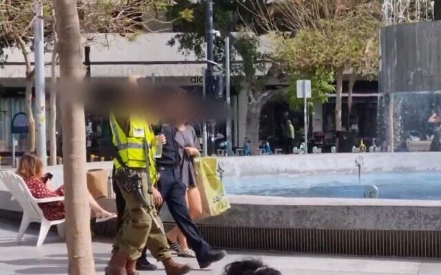 Des soldats des commandos en formation patrouillent avec un agent de police sur la place Dizengoff de Tel Aviv, le 10 avril 2023. (Capture d'écran : Ynet news; used in accordance with Clause 27a of the Copyright Law) Des soldats des commandos en formation patrouillent avec un agent de police sur la place Dizengoff de Tel Aviv, le 10 avril 2023. (Capture d'écran : Ynet news; used in accordance with Clause 27a of the Copyright Law)