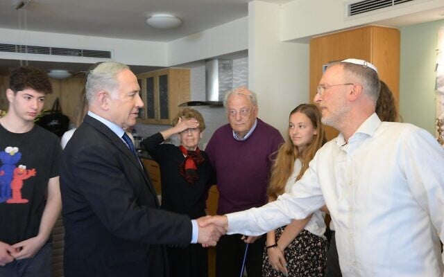 Le Premier ministre Benjamin Netanyahu (à gauche) serrant la main du rabbin Leo Dee, qui a perdu son épouse et deux de ses filles dans une fusillade terroriste, lors d'une visite de condoléances, à Efrat, le 16 avril 2023. (Crédit : Amos Ben-Gershom/GPO)