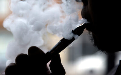 Un homme fumant une cigarette électronique, à Chicago, le 23 avril 2014. (Crédit : AP Photo/Nam Y. Huh)