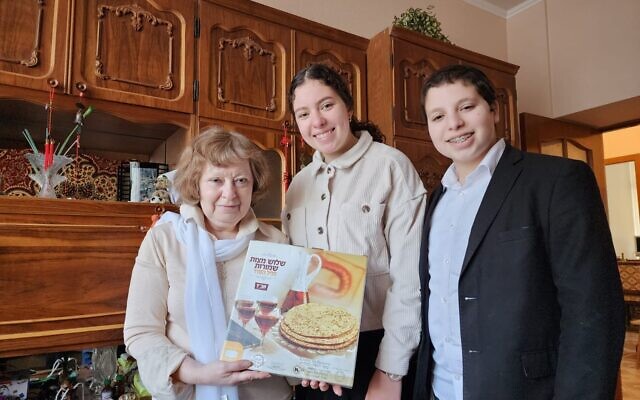 Les enfants du rabbin Children of Kharkiv Rabbi Moshe Moskowitz de Kharkiv remettent de la matsa à une habitante juive, le 30 mars 2023. (Crédit : Rabbi Moshe Moskowitz)