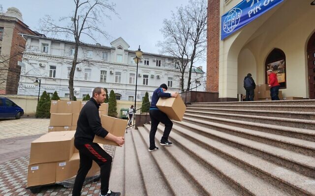 Des employés amènent des boîtes de Matsa dans la synagogue chorale de Kharkiv, le 30 mars 2023. (Crédit : Rabbi Moshe Moskowitz)