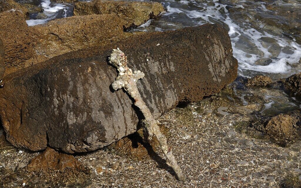 Une photo prise le 19 octobre 2021 montre une ancienne épée d'un mètre de long qui, selon les experts, date de l'époque des croisades et aurait appartenu à un croisé. Elle a été exposée sur la plage de Césarée, quelques jours après avoir été découverte par un plongeur local. (Crédit : Jack Guez/AFP)