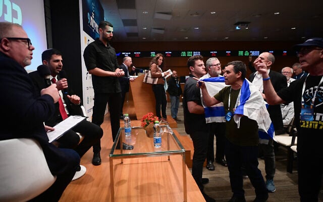Des Israéliens protestent contre l'apparition du ministre des Communications Shlomo Karhi lors d'une conférence libertaire à Tel Aviv, le 30 avril 2023. (Crédit : Avshalom Sassoni/ Flash90) Des Israéliens protestent contre l'apparition du ministre des Communications Shlomo Karhi lors d'une conférence libertaire à Tel Aviv, le 30 avril 2023. (Crédit : Avshalom Sassoni/ Flash90)