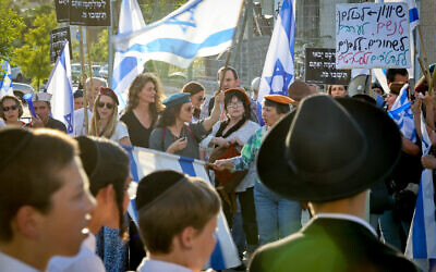 Des Israéliens participent à une manifestation contre les exemptions de service militaire pour les étudiants ultra-orthodoxes des yeshivas et la réforme judiciaire prévue par le gouvernement, devant la yeshiva Kol Torah à Jérusalem, le 4 mai 2023. (Crédit : Noam Revkin Fenton/Flash90)