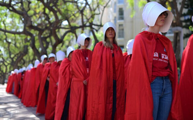 Des Israéliennes déguisées en personnages de la série télévisée The Handmaid's Tale protestent contre les désavantages dont souffrent les femmes dans les tribunaux rabbiniques de l'État et contre le projet de réforme judiciaire du gouvernement, devant le tribunal rabbinique de Tel-Aviv, le 4 mai 2023. (Crédit : Tomer Neuberg/Flash90) Des Israéliennes déguisées en personnages de la série télévisée The Handmaid's Tale protestent contre les désavantages dont souffrent les femmes dans les tribunaux rabbiniques de l'État et contre le projet de réforme judiciaire du gouvernement, devant le tribunal rabbinique de Tel-Aviv, le 4 mai 2023. (Crédit : Tomer Neuberg/Flash90)