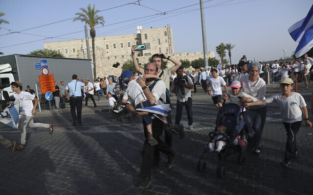 Des Israéliens courent vers des abris alors que les sirènes d'alerte aux roquettes retentissent lors du défilé pour la Journée de Jérusalem, le 10 mai 2021. (Crédit : Ariel Schalit/AP) Des Israéliens courent vers des abris alors que les sirènes d'alerte aux roquettes retentissent lors du défilé pour la Journée de Jérusalem, le 10 mai 2021. (Crédit : Ariel Schalit/AP)