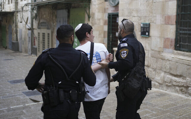 Des policiers arrêtent un jeune Israélien après que son groupe a scandé des slogans à l'entrée de l'enceinte de la mosquée Al Aqsa lors de la Marche annuelle des drapeaux dans la Vieille Ville de Jérusalem, le 18 mai 2023. Illustration : (Crédit : Maya Alleruzzo/AP) Des policiers arrêtent un jeune Israélien après que son groupe a scandé des slogans à l'entrée de l'enceinte de la mosquée Al Aqsa lors de la Marche annuelle des drapeaux dans la Vieille Ville de Jérusalem, le 18 mai 2023. Illustration : (Crédit : Maya Alleruzzo/AP)