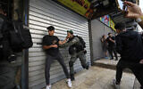 La police israélienne repousse des Palestiniens d'une rue du quartier musulman de la Vieille Ville de Jérusalem, peu avant une marche de nationalistes juifs dans le quartier, jeudi 18 mai 2023. (Crédit : Ohad Zwigenberg/AP)
