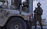 Les soldats israéliens montent la garde pendant une opération près du carrefour de Jit, à l'Oest de Naplouse, en Cisjordanie, le 12 mars 2023. (Crédit :  jaafar ashtiyeh / AFP)