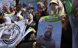 Des Palestiniens de Gaza City tiennent le portrait de Khader Adnan, membre du groupe du Jihad islamique palestinien mort dans une prison israélienne des suites d'une grève de la faim de 86 jours, le 2 mai 2023. (Crédit : Mohammed Abed/AFP)