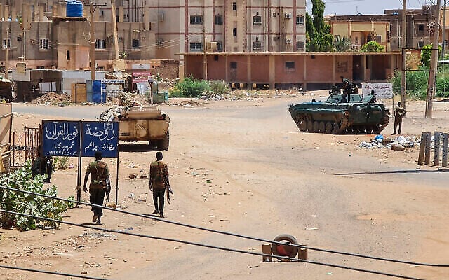Des soldats de l'armée soudanaise marchent à proximité de véhicules blindés stationnés dans une rue du sud de Kharoum, le 6 mai 2023. (Crédit : AFP) Des soldats de l'armée soudanaise marchent à proximité de véhicules blindés stationnés dans une rue du sud de Kharoum, le 6 mai 2023. (Crédit : AFP)