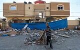 Un Palestinien inspectant la maison lourdement endommagée du chef du Jihad islamique palestinien, Jihad Ghannam, tué lors d'une frappe aérienne israélienne à Rafah, dans le sud de la bande de Gaza, le 9 mai 2023. (Crédit : Saïd Khatib/AFP)