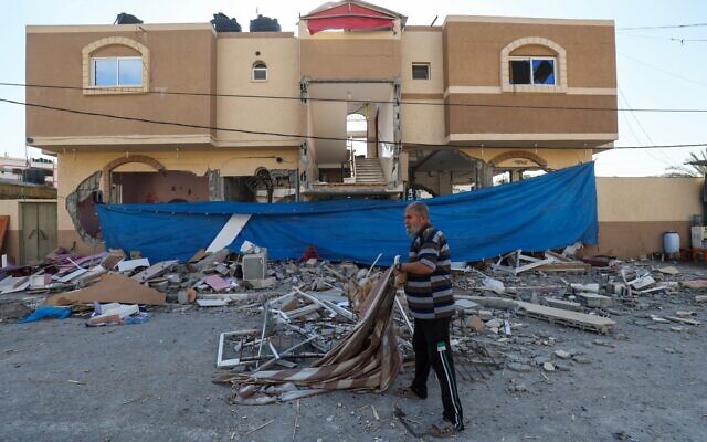 Un Palestinien inspectant la maison lourdement endommagée du chef du Jihad islamique palestinien, Jihad Ghannam, tué lors d'une frappe aérienne israélienne à Rafah, dans le sud de la bande de Gaza, le 9 mai 2023. (Crédit : Saïd Khatib/AFP) Un Palestinien inspectant la maison lourdement endommagée du chef du Jihad islamique palestinien, Jihad Ghannam, tué lors d'une frappe aérienne israélienne à Rafah, dans le sud de la bande de Gaza, le 9 mai 2023. (Crédit : Saïd Khatib/AFP)