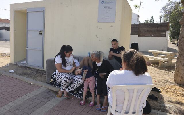 Des habitants de la ville d'Ashkelon, dans le sud d'Israël, assis devant un abri anti-bombes, alors que les tensions entre les terroristes palestiniens de la Bande de Gaza et Israël s'intensifient, le 10 mai 2023. (Crédit : Menahem Kahana/AFP) Des habitants de la ville d'Ashkelon, dans le sud d'Israël, assis devant un abri anti-bombes, alors que les tensions entre les terroristes palestiniens de la Bande de Gaza et Israël s'intensifient, le 10 mai 2023. (Crédit : Menahem Kahana/AFP)