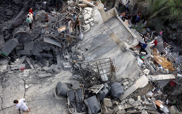 Des Palestiniens inspectent les décombres d'un bâtiment après une frappe israélienne à Beit Lahia, dans le nord de la bande de Gaza, le 11 mai 2023. (Crédit : MOHAMMED ABED / AFP) Des Palestiniens inspectent les décombres d'un bâtiment après une frappe israélienne à Beit Lahia, dans le nord de la bande de Gaza, le 11 mai 2023. (Crédit : MOHAMMED ABED / AFP)