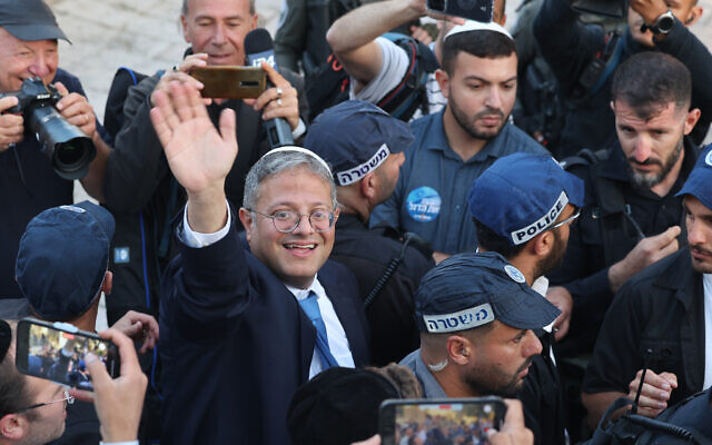 Le ministre de la Sécurité nationale, Itamar Ben Gvir, entouré d'officiers de police, salue les personnes rassemblées devant la porte de Damas menant à la Vieille Ville de Jérusalem, le 18 mai 2023. (Crédit : AHMAD GHARABLI / AFP) Le ministre de la Sécurité nationale, Itamar Ben Gvir, entouré d'officiers de police, salue les personnes rassemblées devant la porte de Damas menant à la Vieille Ville de Jérusalem, le 18 mai 2023. (Crédit : AHMAD GHARABLI / AFP)