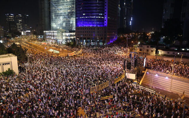 Des manifestants soulevant des drapeaux lors d'un rassemblement de protestation contre les projets de réforme du système judiciaire du gouvernement, à Tel Aviv, le 27 mai 2023. (Crédit : Jack Guez/AFP)