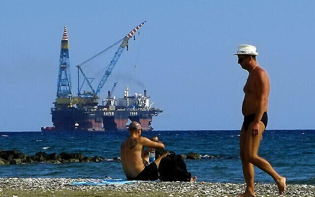 Illustration : Des personnes sur une plage avec une plate-forme de forage en arrière-plan, aux environs du port de Larnaca, dans l’île méditerranéenne orientale de Chypre, le 15 octobre 2017. (Crédit : Petros Karadjias/AP) Illustration : Des personnes sur une plage avec une plate-forme de forage en arrière-plan, aux environs du port de Larnaca, dans l’île méditerranéenne orientale de Chypre, le 15 octobre 2017. (Crédit : Petros Karadjias/AP)