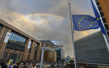Le drapeau de l'Union européenne est en berne alors qu'un double arc-en-ciel se forme au-dessus du bâtiment du Conseil européen à Bruxelles, le 9 septembre 2022. (Crédit : AP Photo/Olivier Matthys)