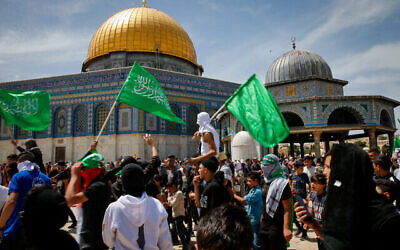 Des manifestants brandissant des drapeaux du Hamas après la prière du vendredi du ramadan, dans l'enceinte de la mosquée Al Aqsa, dans la Vieille Ville de Jérusalem, le 22 avril 2022. (Crédit : Jamal Awad/Flash90)