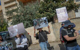 Des membres de l'ONG de gauche Breaking the Silence tenant des images montrant des abus commis par l'armée israélienne, lors d'une visite dans la ville de Hébron, en Cisjordanie, le 2 novembre 2022. (Crédit : Flash90)