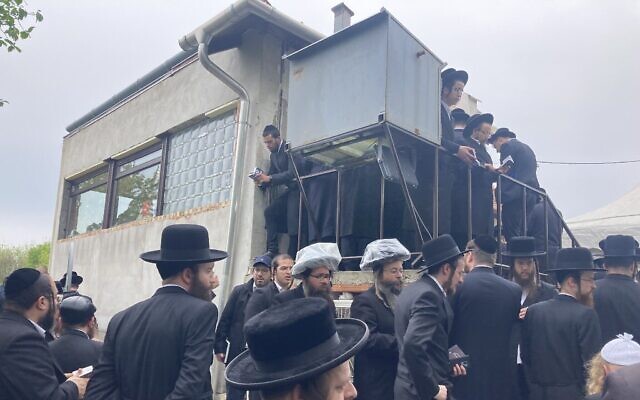 Des juifs hassidiques prient près de la tombe de Yeshaya Steiner à Bodrogkeresztur, en Hongrie, le 24 avril 2023. (Crédit : Yaakov Schwartz/ Times of Israel)