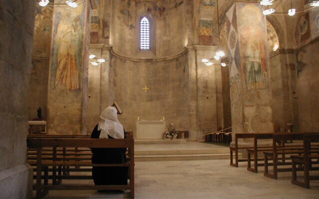Une religieuse assise à l'intérieur de l'église des Croisés à Abu Ghosh, en octobre 2021. (Crédit : Shmuel Bar-Am)