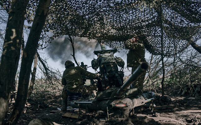 Des soldats ukrainiens tirent au canon près de Bakhmut dans la région de Donetsk, en Ukraine, le 3 mai 2023. (Crédit : Libkos/AP) Des soldats ukrainiens tirent au canon près de Bakhmut dans la région de Donetsk, en Ukraine, le 3 mai 2023. (Crédit : Libkos/AP)