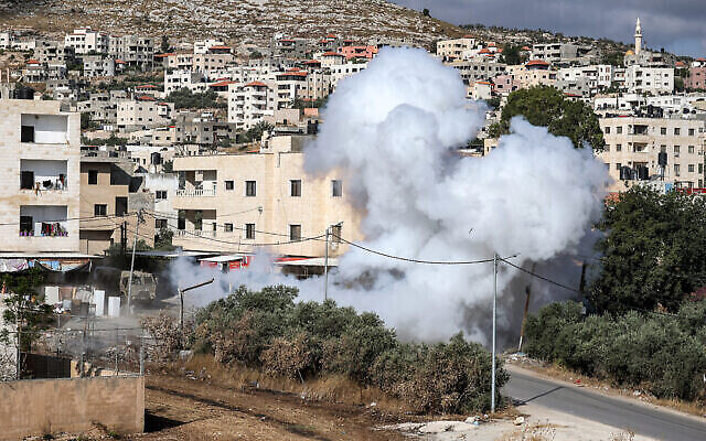 De la fumée s'échappe de la détonation d'une charge explosive laissée par des tireurs palestiniens le long d'une route lors d'un raid de l'armée israélienne à Jénine en Cisjordanie, le 19 juin 2023. (Crédit : Jaafar ASHTIYEH / AFP)