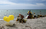 Un mémorial avec des fleurs, des croix et des ballons sur une plage près de Cutro, avec la mer Méditerranée en arrière-plan, où au moins 72 migrants sont morts le 26 février, après que leur bateau a coulé dans la région de la Calabre du sud de l'Italie, le 9 mars 2023. (Crédit : Tiziana FABI / AFP)