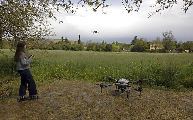 Une photo prise le 13 avril 2023 montre un employé de la société de technologie agronomique AgroScout pilotant un drone dans le kibboutz de Yiron, au nord d'Israël. (Crédit : Menahem Kahana/AFP)