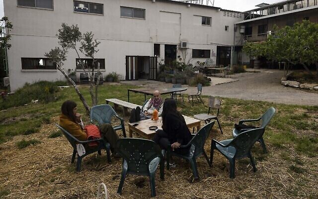 Des habitants sont assis ensemble au kibboutz Hanita le 13 avril 2023. (Crédit : Menahem Kahana/AFP)
