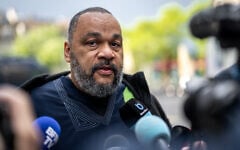 Le polémiste français Dieudonné M’Bala M’Bala au deuxième jour du procès de Tariq Ramadan au palais de justice de Genève, le 16 mai 2023. (Crédit : Fabrice COFFRINI / AFP)