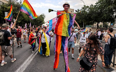 Une personne en costume arc-en-ciel sur des échasses lors de la 21e marche annuelle des fiertés à Jérusalem, le 1er juin 2023. (Crédit : Menahem KAHANA / AFP) Une personne en costume arc-en-ciel sur des échasses lors de la 21e marche annuelle des fiertés à Jérusalem, le 1er juin 2023. (Crédit : Menahem KAHANA / AFP)