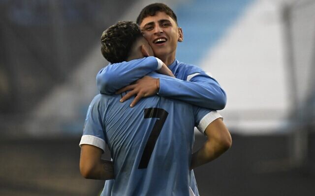 Le milieu de terrain uruguayen Ignacio Sosa, à l'arrière, étreignant le milieu de terrain uruguayen Anderson Duarte après avoir battu Israël lors du match de demi-finale de la Coupe du monde U-20 Argentine 2023 entre l'Uruguay et Israël, au stade Estadio Unico Diego Armando Maradona à La Plata, en Argentine, le 8 juin 2023. (Crédit : Luis  Robayo/AFP)
