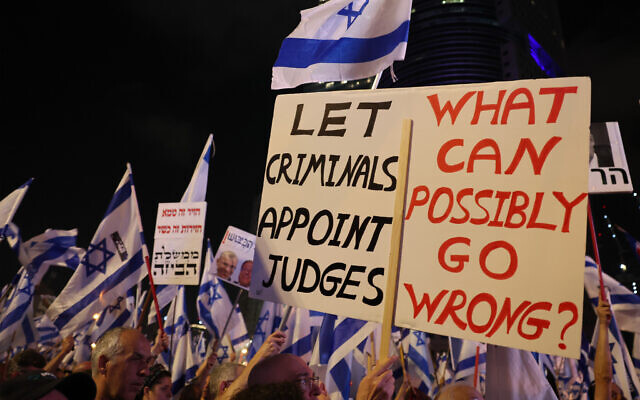 Des Israéliens brandissant des drapeaux nationaux et des pancartes alors qu'ils protestent contre les projets controversés du gouvernement de droite radicale de réformer le système judiciaire, à Tel Aviv, le 10 juin 2023. (Crédit : Jack Guez/AFP) Des Israéliens brandissant des drapeaux nationaux et des pancartes alors qu'ils protestent contre les projets controversés du gouvernement de droite radicale de réformer le système judiciaire, à Tel Aviv, le 10 juin 2023. (Crédit : Jack Guez/AFP)