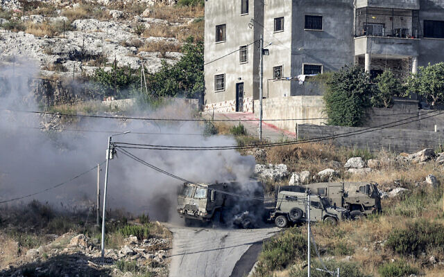 De la fumée s'échappe de la détonation d'une charge explosive palestinienne sur un véhicule blindé israélien lors d'un raid de l'armée israélienne à Jénine, en Cisjordanie, le 19 juin 2023. (Jaafar ASHTIYEH / AFP)