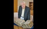 Alfred Moses avec le Codex Sassoon qu'il a acheté pour l'offrir au musée du peuple juif de Tel Aviv. (Crédit :Perry Bindelglass for The American Friends of ANU The Museum of the Jewish People via JTA)