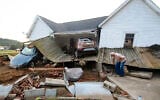 Ernest Hollis cherchant des objets dans la maison de sa petite-fille qui a été dévastée par les inondations, à Waverly, dans le Tennessee, le 23 août 2021. (Crédit : AP Photo/John Amis)